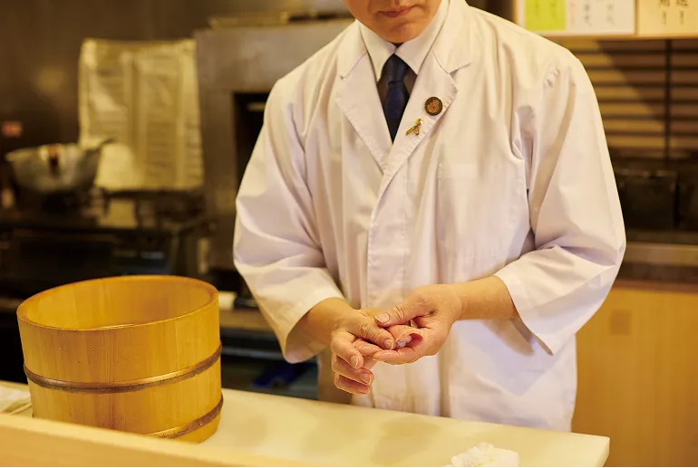 大将が寿司をにぎる様子